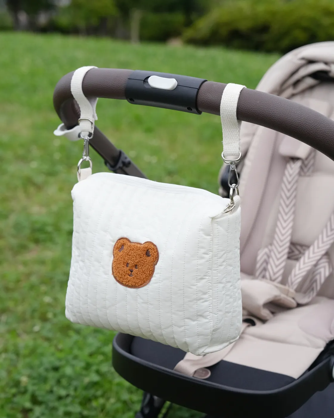 選べる購入特典B くまワッペン付きバッグをベビーカーのハンドルに取り付けた様子（ストラップ含む全体）